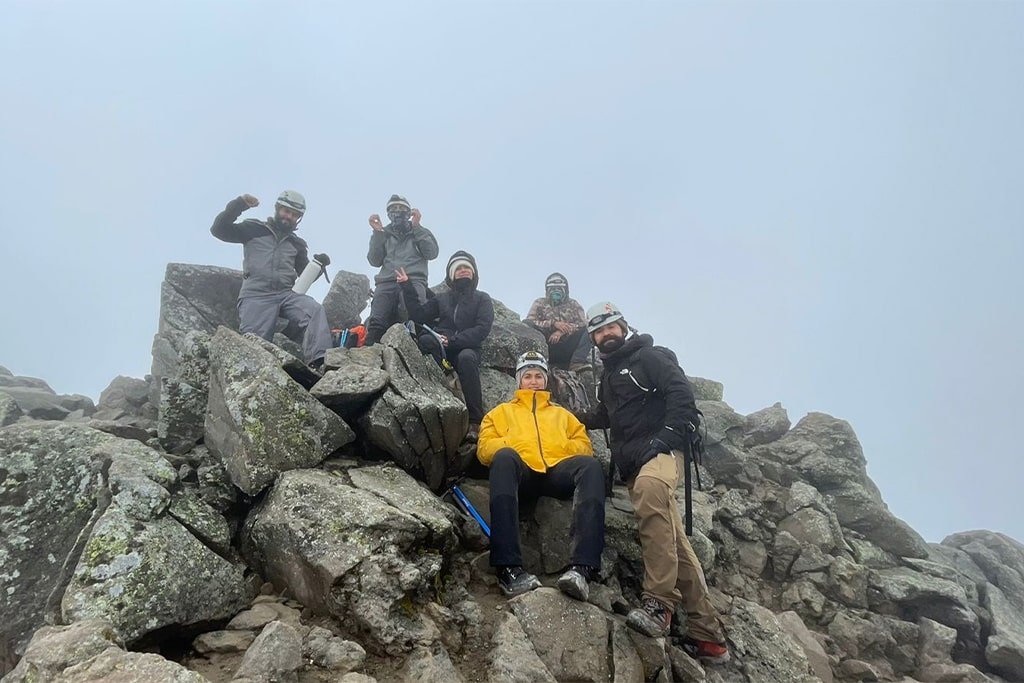 A group celebrating on the rocky summit