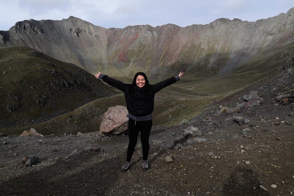Arms wide open below the colorful crater walls