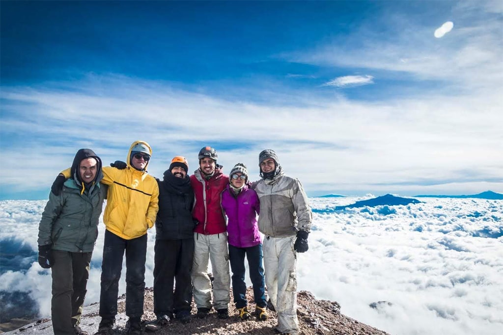 Hikers together above a sea of clouds