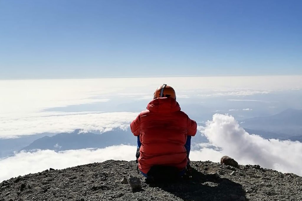 Resting on the crater rim above the clouds